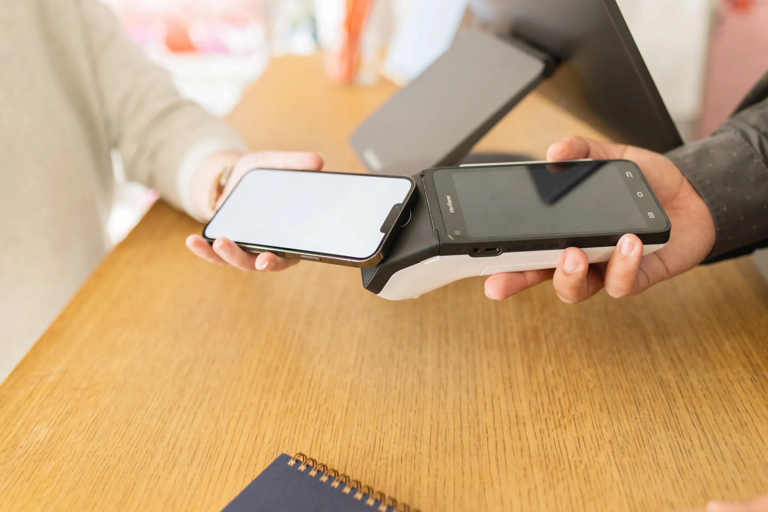 Customer using tap-to-pay with their smartphone, a convenient payment method supported by Armagh POS systems using Verifone hardware.