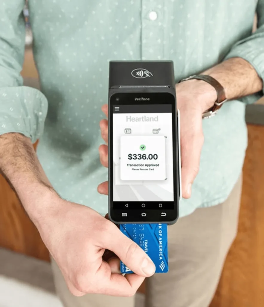 Verifone Heartland payment terminal displaying a $336.00 approved transaction with a card inserted.