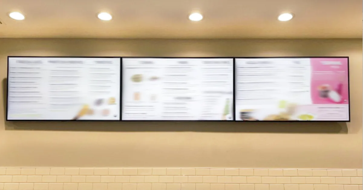 Three landscape digital menu boards mounted above a restaurant counter