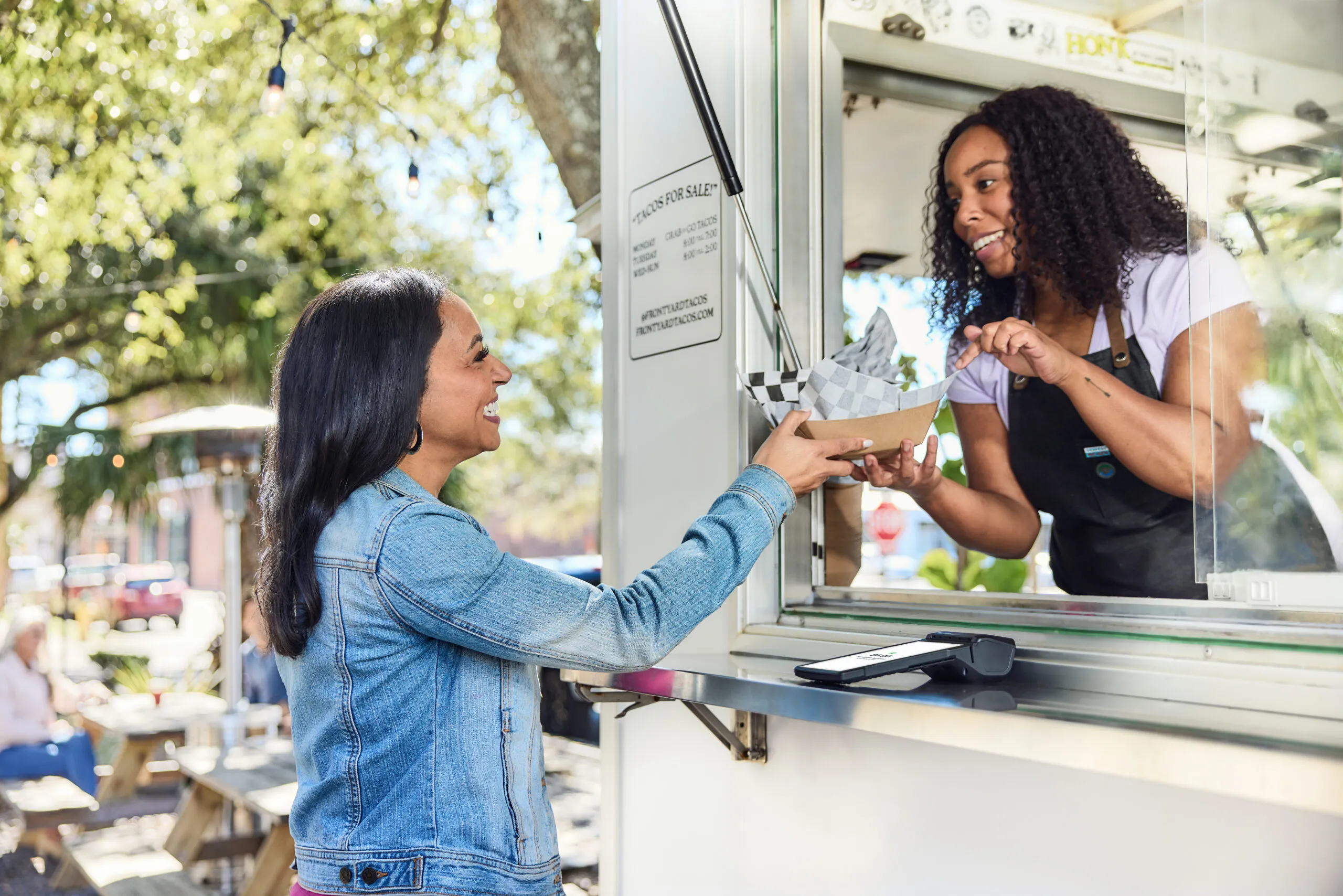 Armagh POS system facilitating easy payments at a bustling food truck, as a happy customer receives her meal